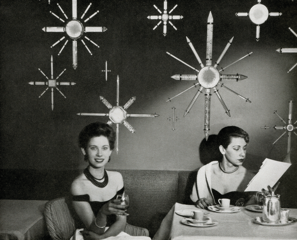 Dining in front of a decorative wall panel on the SS United States.