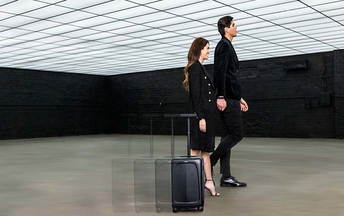 People walking alongside the Ovis self-driving suitcase
